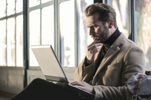 Photo of a guy confused while looking at a computer.