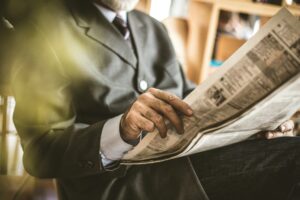 Photo of a man reading a newspaper.