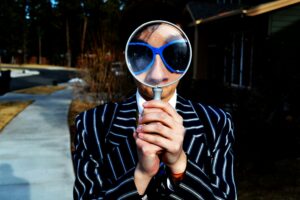 Photo of a person looking through a magnifyer.