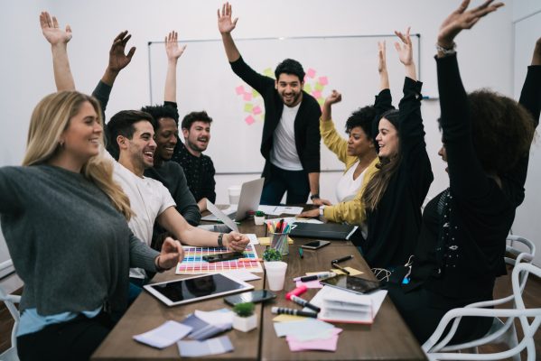 Business team celebrating with raised up hands.