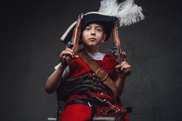 Funny kid with painted moustache and guns